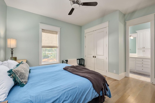 bedroom with a closet, light wood-type flooring, baseboards, a ceiling fan, and ensuite bathroom