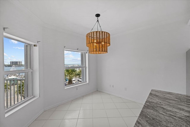 212 Harbor Blvd Unit 205, Destin, FL 32541 - unfurnished dining area featuring a chandelier, a water view, crown molding, baseboards, and light tile patterned flooring