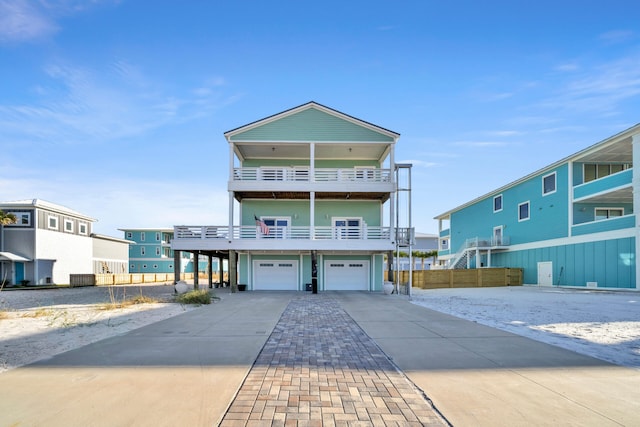 view of front of home featuring concrete driveway, a garage, and a balcony