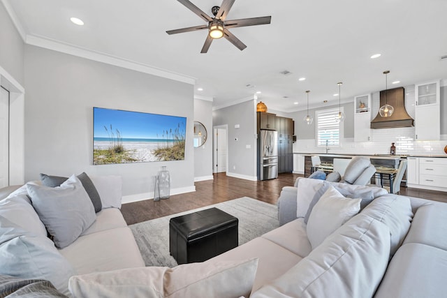 living area with dark wood-type flooring, ceiling fan, recessed lighting, and crown molding