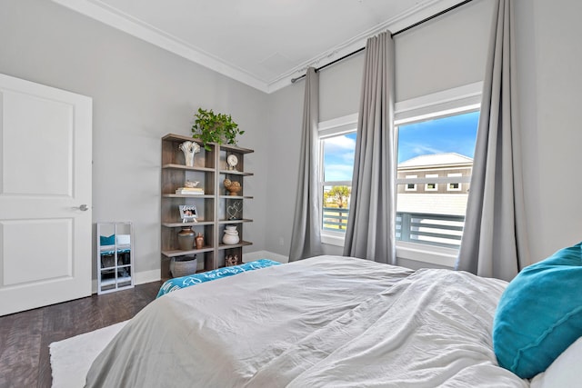 bedroom featuring baseboards, ornamental molding, and wood finished floors