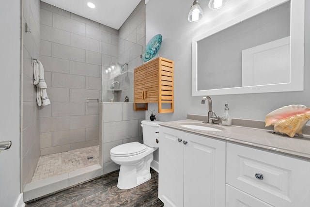 bathroom featuring walk in shower, toilet, recessed lighting, wood finished floors, and vanity