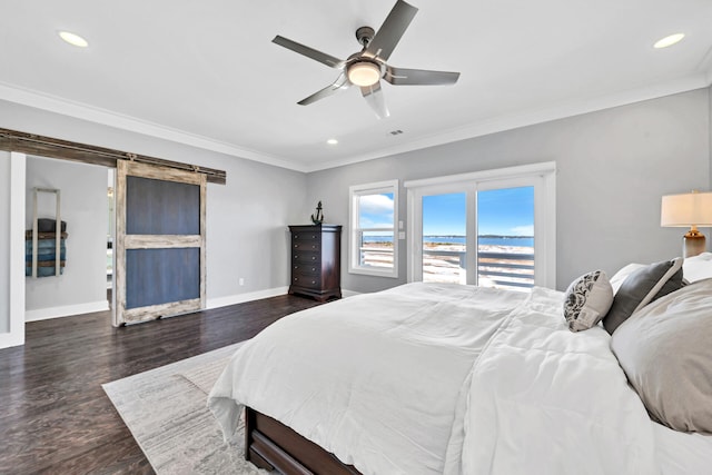 bedroom with recessed lighting, wood finished floors, a barn door, baseboards, and crown molding