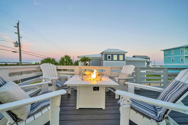 deck at dusk featuring a fire pit
