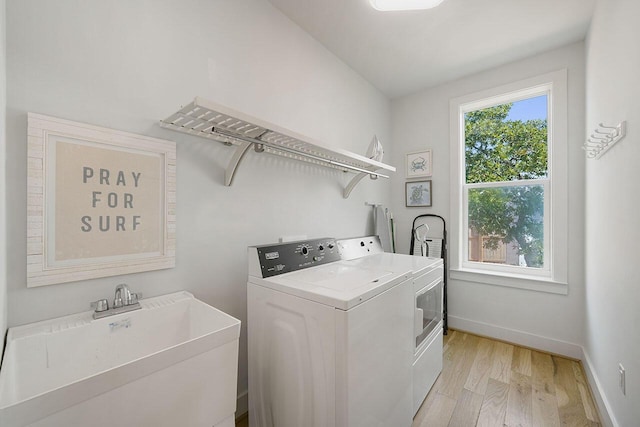 54 Dune Dr, Santa Rosa Beach, FL 32459 - washroom featuring washing machine and clothes dryer, light wood finished floors, baseboards, laundry area, and a sink