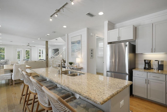 54 Dune Dr, Santa Rosa Beach, FL 32459 - kitchen featuring light wood finished floors, a sink, light stone counters, and freestanding refrigerator