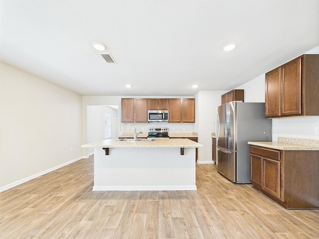 643 Earl Godwin Rd, Freeport, FL 32439 - kitchen featuring stainless steel appliances, a sink, light wood-style flooring, a kitchen bar, and an island with sink