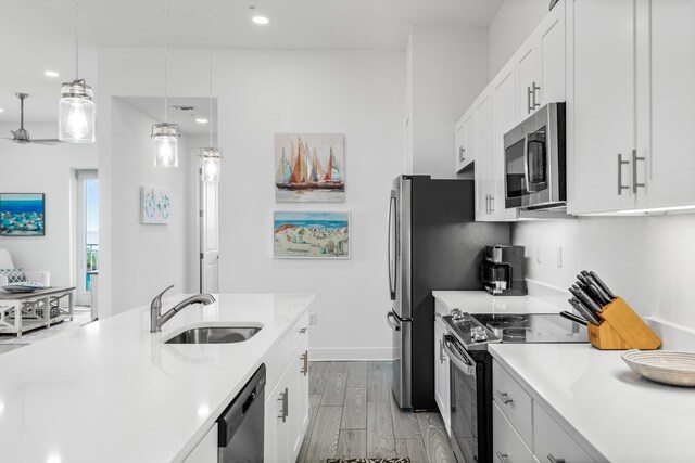 1740 S County Highway 393 # 301, Santa Rosa Beach, FL 32459 - kitchen with light countertops, a sink, wood finished floors, appliances with stainless steel finishes, and white cabinets