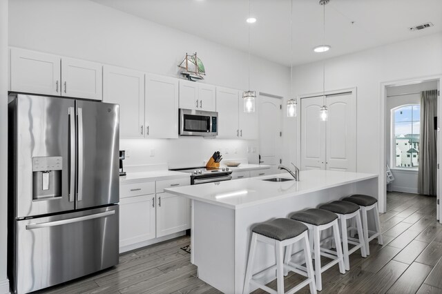 1740 S County Highway 393 # 301, Santa Rosa Beach, FL 32459 - kitchen featuring white cabinets, visible vents, stainless steel appliances, and wood finished floors