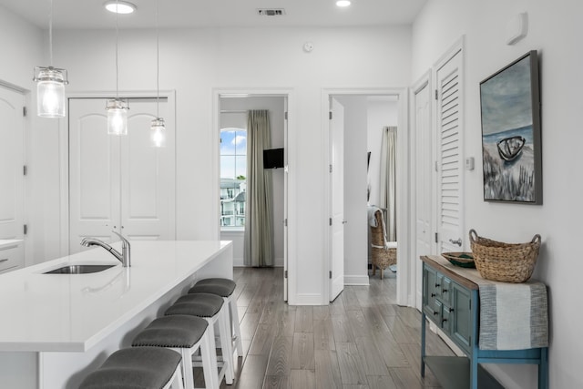 1740 S County Highway 393 # 301, Santa Rosa Beach, FL 32459 - kitchen featuring light countertops, a kitchen bar, a sink, visible vents, and wood finished floors