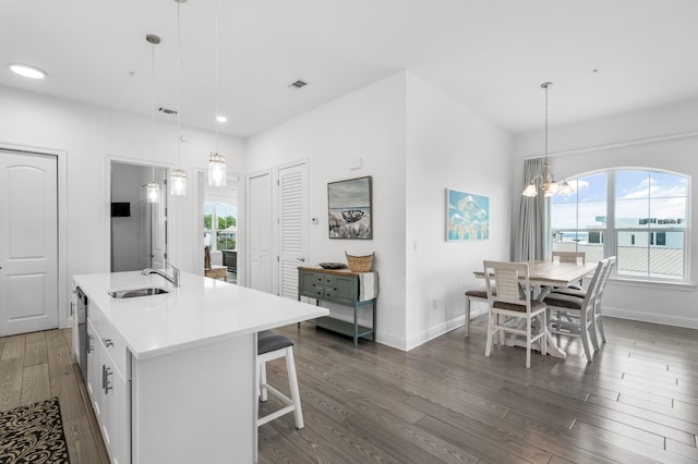 1740 S County Highway 393 # 301, Santa Rosa Beach, FL 32459 - kitchen with light countertops, dark wood-type flooring, baseboards, a sink, and an island with sink