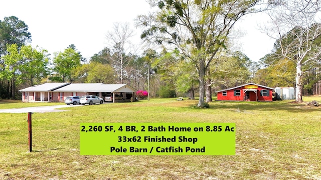 view of yard with concrete driveway and a carport