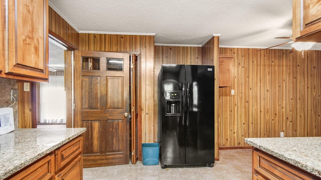2374 County Highway 280a, Defuniak Springs, FL 32435 - kitchen featuring black refrigerator with ice dispenser, crown molding, wooden walls, a ceiling fan, and light stone counters