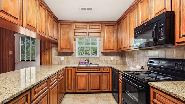 2374 County Highway 280a, Defuniak Springs, FL 32435 - kitchen featuring black appliances, a sink, brown cabinetry, tasteful backsplash, and light stone countertops