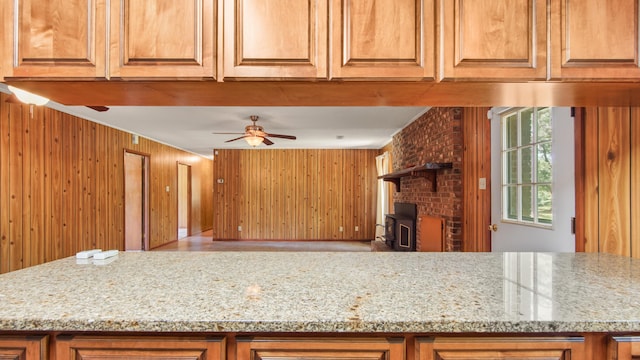 2374 County Highway 280a, Defuniak Springs, FL 32435 - kitchen with a ceiling fan, wooden walls, light stone countertops, and brown cabinets