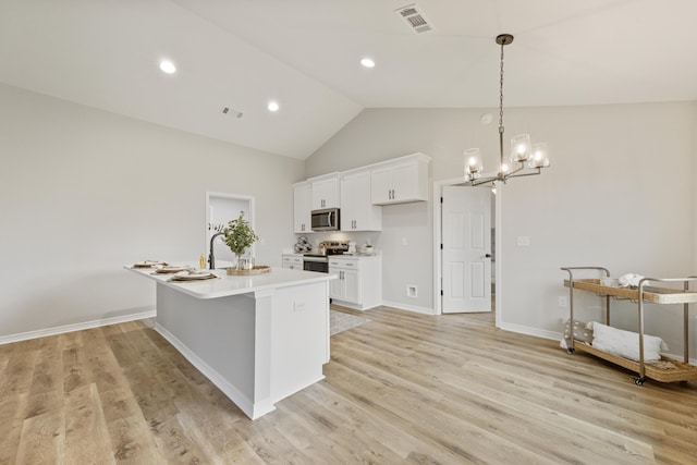 3202 Liz Ct, Crestview, FL 32539 - kitchen featuring appliances with stainless steel finishes, a chandelier, light countertops, white cabinets, and light wood-style floors
