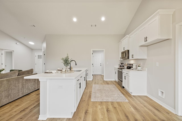 3202 Liz Ct, Crestview, FL 32539 - kitchen featuring stainless steel appliances, open floor plan, vaulted ceiling, a sink, and an island with sink