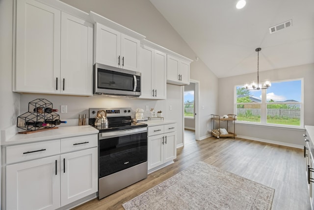 3202 Liz Ct, Crestview, FL 32539 - kitchen with appliances with stainless steel finishes, vaulted ceiling, light wood-style flooring, light countertops, and white cabinetry