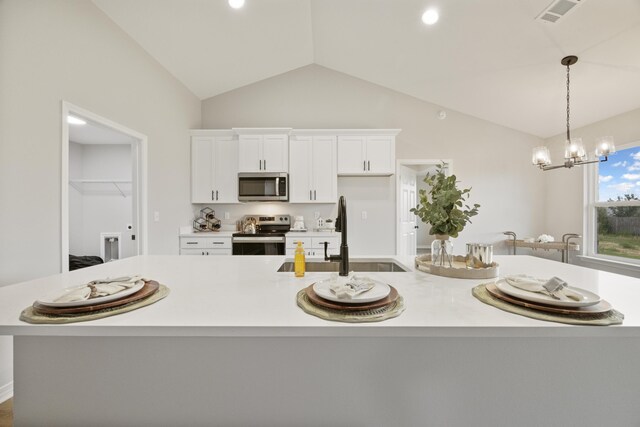 3202 Liz Ct, Crestview, FL 32539 - kitchen featuring stainless steel appliances, a sink, vaulted ceiling, white cabinets, and light countertops