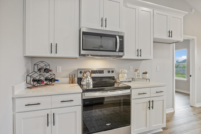 3202 Liz Ct, Crestview, FL 32539 - kitchen with appliances with stainless steel finishes, light wood finished floors, light countertops, and white cabinetry