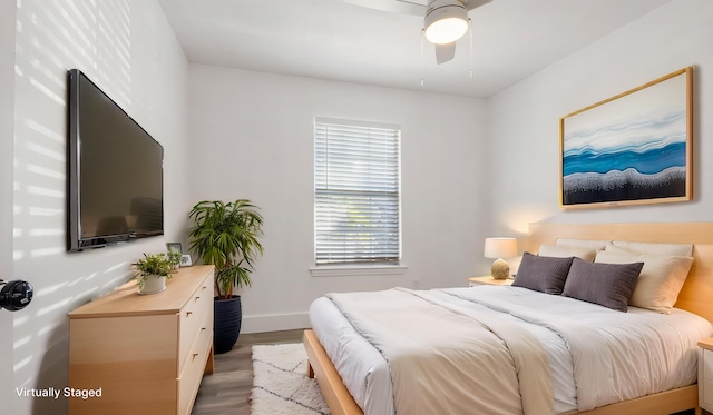 bedroom featuring ceiling fan, wood finished floors, and baseboards