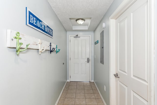 entryway featuring baseboards, light tile patterned floors, and a textured ceiling