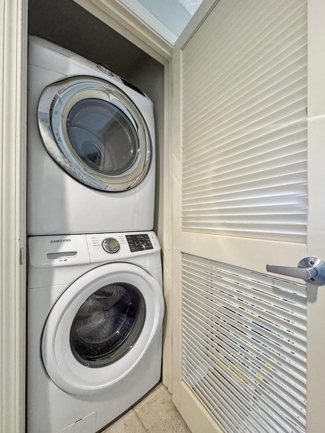 clothes washing area featuring stacked washer and dryer and laundry area