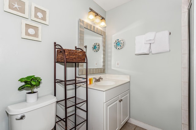 bathroom featuring toilet, vanity, and baseboards