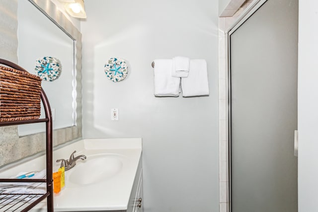full bathroom with a shower with door and vanity