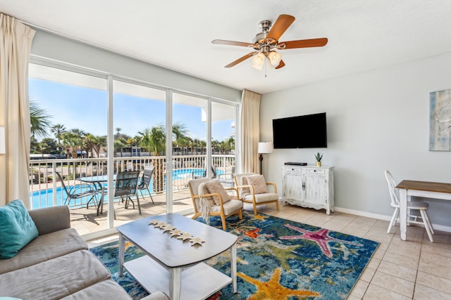 living area featuring a ceiling fan, light tile patterned flooring, and baseboards