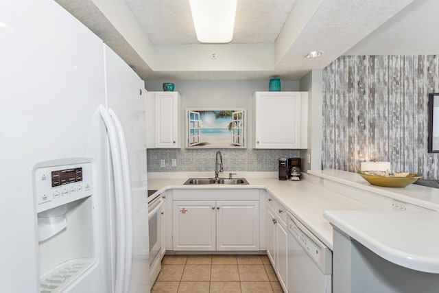 kitchen featuring decorative backsplash, light tile patterned flooring, white appliances, white cabinetry, and a sink
