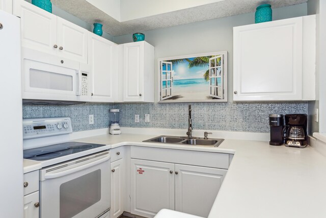 kitchen featuring light countertops, a sink, white cabinetry, white appliances, and decorative backsplash