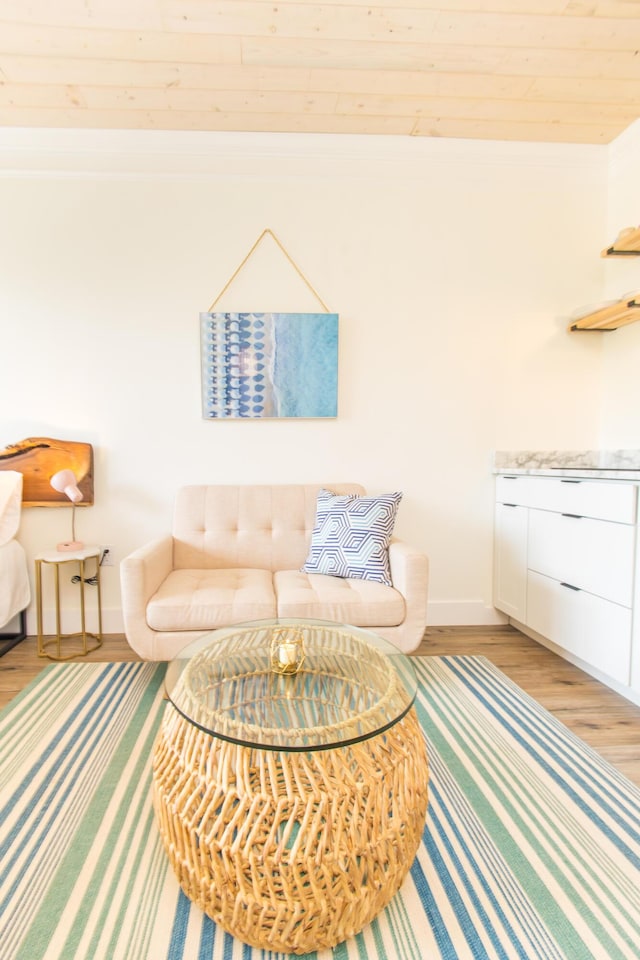 sitting room with baseboards, ornamental molding, and light wood finished floors