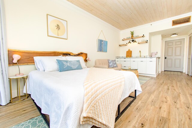 bedroom with wood ceiling, ornamental molding, light wood finished floors, and visible vents