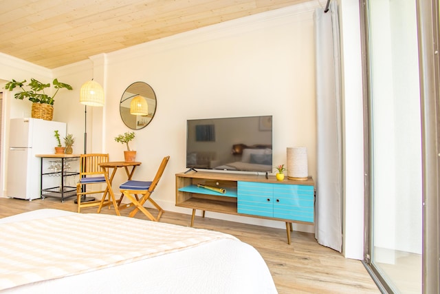 bedroom with freestanding refrigerator, crown molding, and wood finished floors