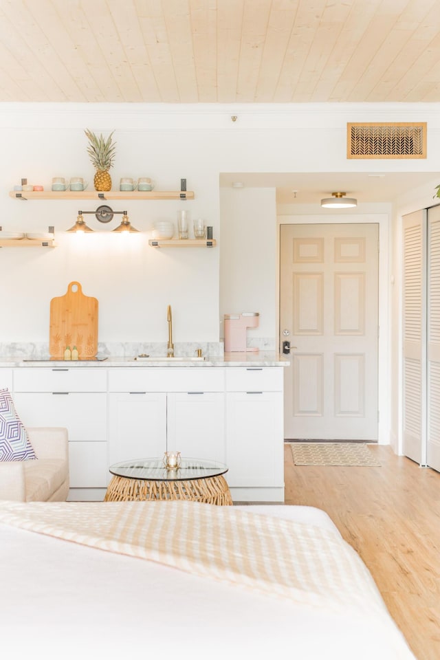 interior space featuring crown molding, wood ceiling, visible vents, and a sink