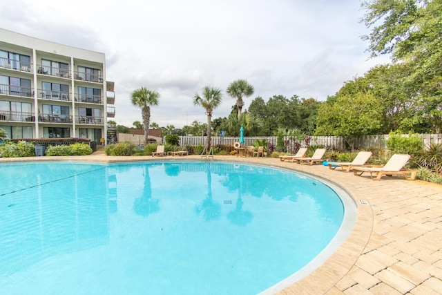 pool featuring fence and a patio area