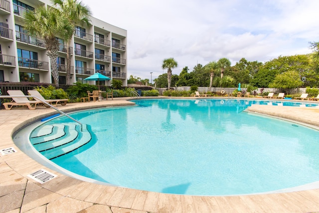 community pool featuring a patio and fence