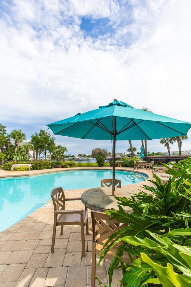 community pool featuring a patio area and fence