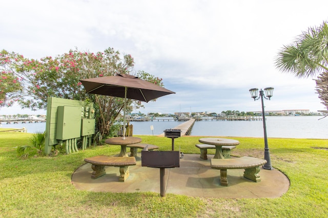 surrounding community with a water view and a yard