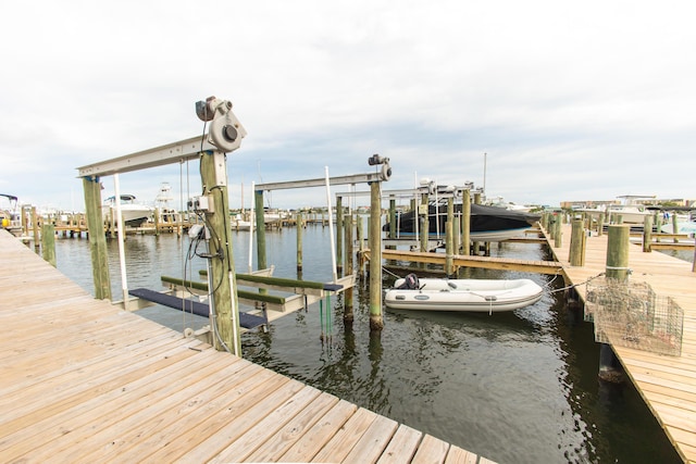 view of dock with boat lift and a water view