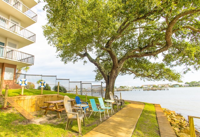 exterior space with a water view and fence