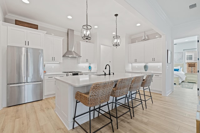 197 Suwannee Dr Lot 18, Watersound, FL 32461 - kitchen featuring an island with sink, freestanding refrigerator, wall chimney exhaust hood, a breakfast bar, and visible vents
