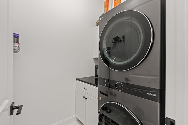 197 Suwannee Dr Lot 18, Watersound, FL 32461 - laundry room featuring stacked washer and clothes dryer, cabinet space, and baseboards