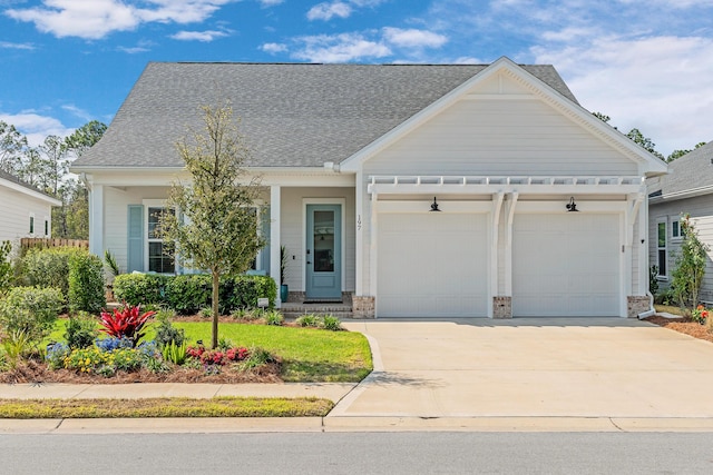 197 Suwannee Dr Lot 18, Watersound, FL 32461 - view of front of house with driveway, a shingled roof, a garage, and stone siding