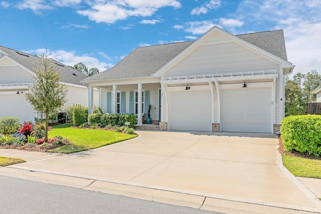 197 Suwannee Dr Lot 18, Watersound, FL 32461 - view of front of house featuring an attached garage, driveway, a front lawn, covered porch, and a shingled roof