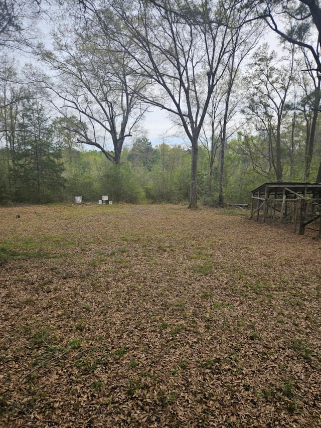 view of yard with an outdoor structure and a view of trees