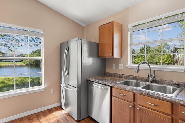309 Wimico Cir, Destin, FL 32541 - kitchen featuring brown cabinetry, a healthy amount of sunlight, stainless steel appliances, and a sink
