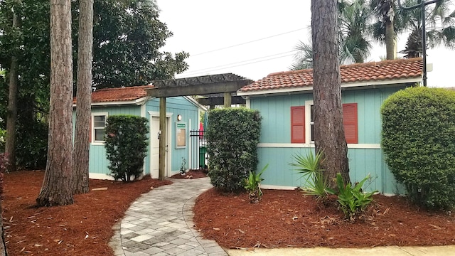 309 Wimico Cir, Destin, FL 32541 - view of front of house featuring a pergola, a tiled roof, and an outdoor structure