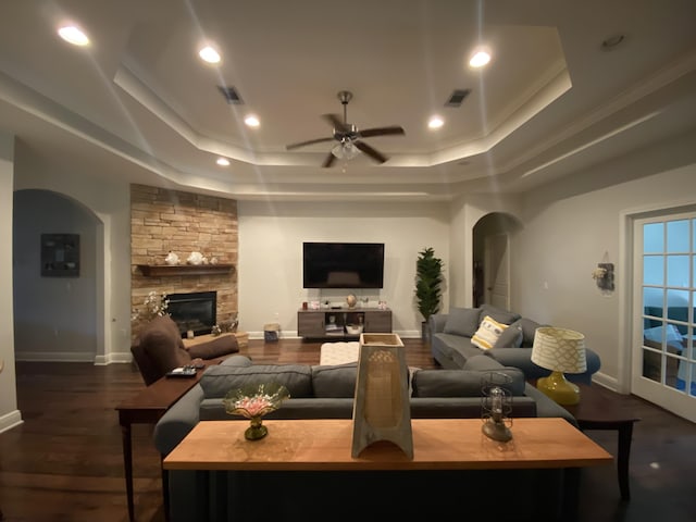 43 Secret St, Freeport, FL 32439 - living area featuring a raised ceiling, arched walkways, ceiling fan, a fireplace, and wood finished floors